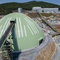 Σκουριές. Θόλος στέγασης προθραυσμένου μεταλλεύματος και στο βάθος το εργοστάσιο επεξεργασίας μεταλλεύματος